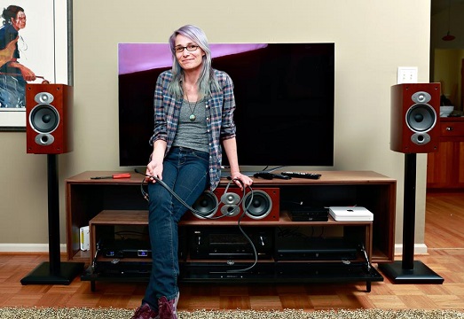 woman sitting on an entertainment console holding a wire